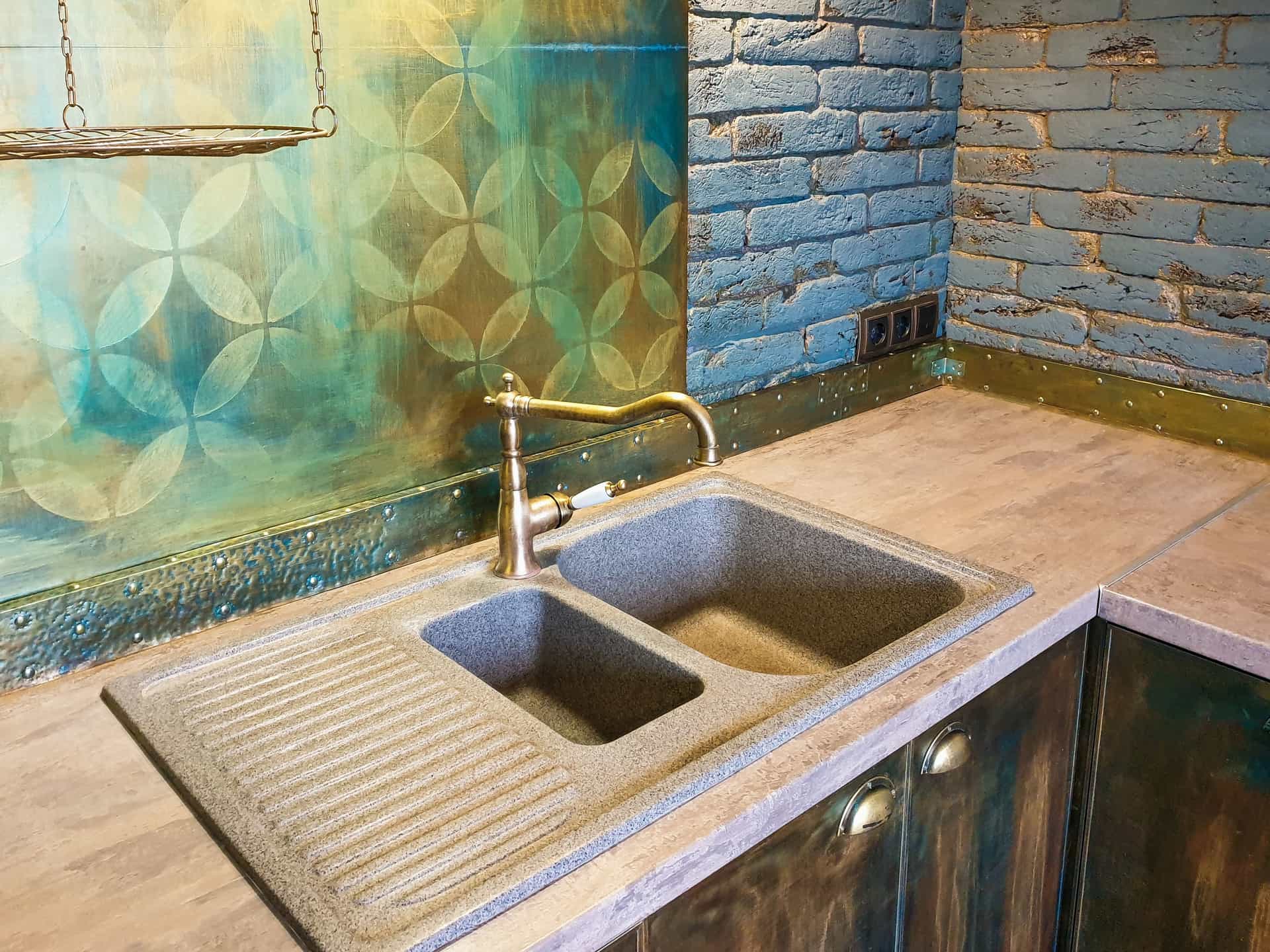Pull-down kitchen faucet over a stainless steel sink in a lived-in kitchen