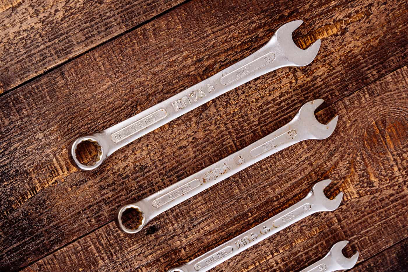 Plumbing hand tools including wrenches laid out on a work surface