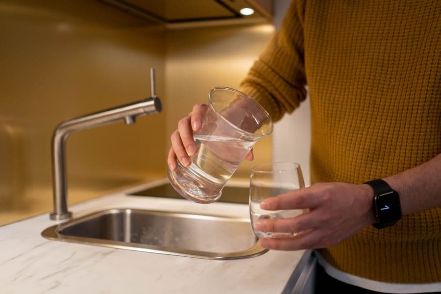 Glass being filled with filtered water at a kitchen faucet