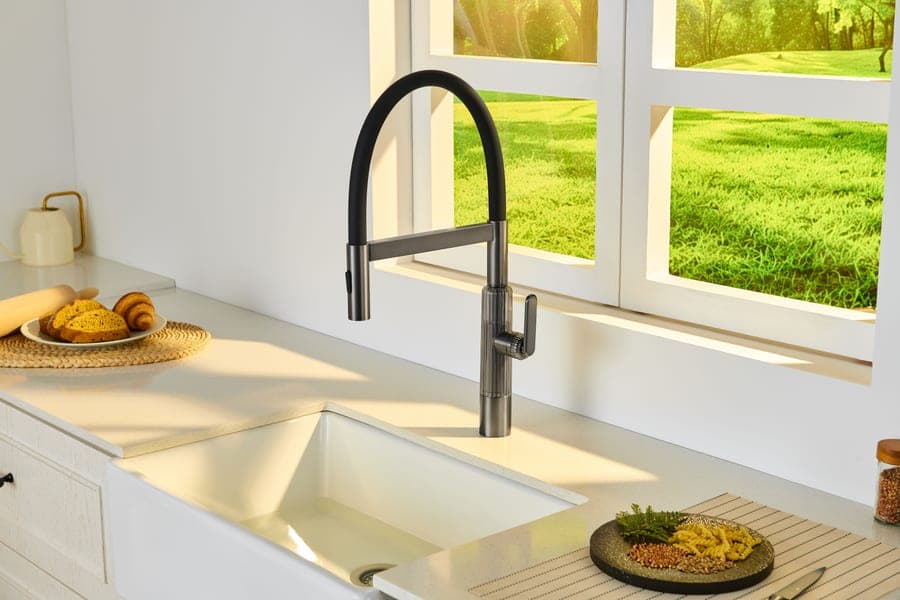 Hand held under a touchless kitchen faucet with water running